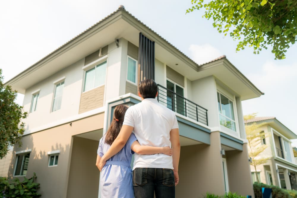 young couple hugging looking new house