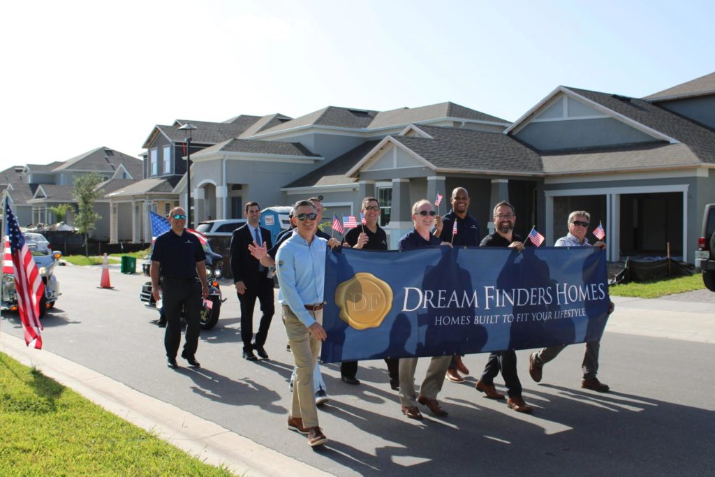 man holding a dream finders homes sign