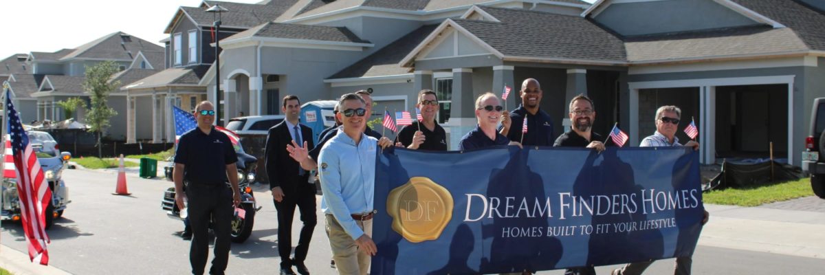 man holding a dream finders homes sign
