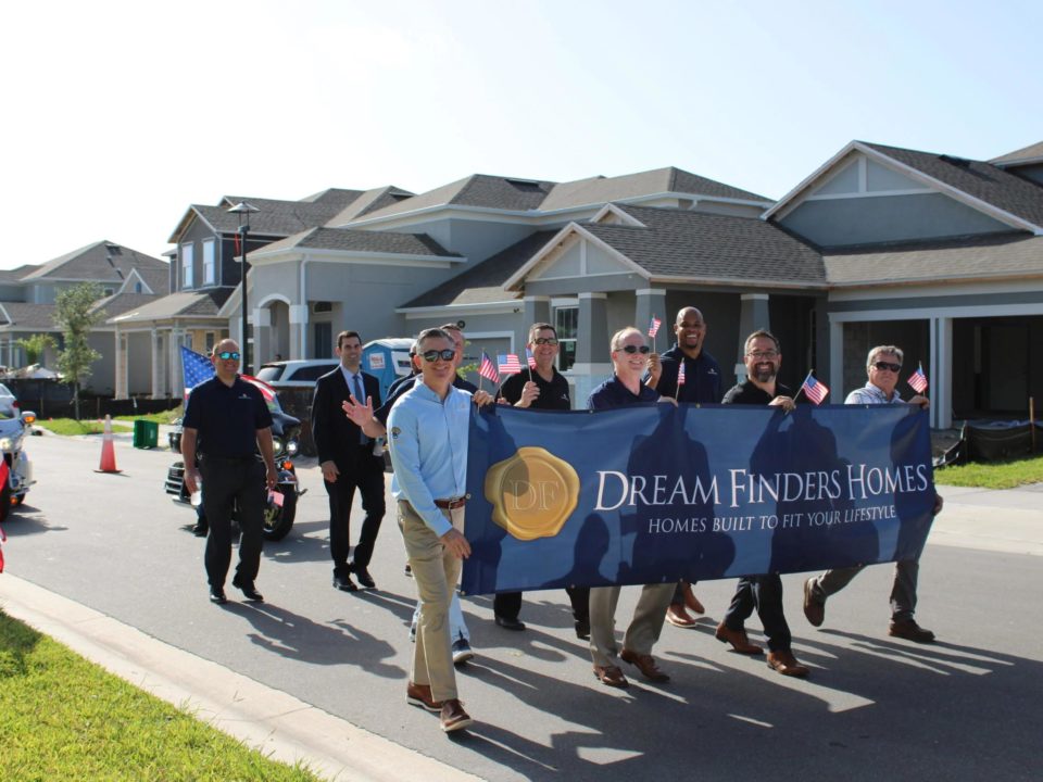 man holding a dream finders homes sign